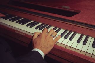 Mains posées sur le clavier d'un piano pendant un exercice de gamme